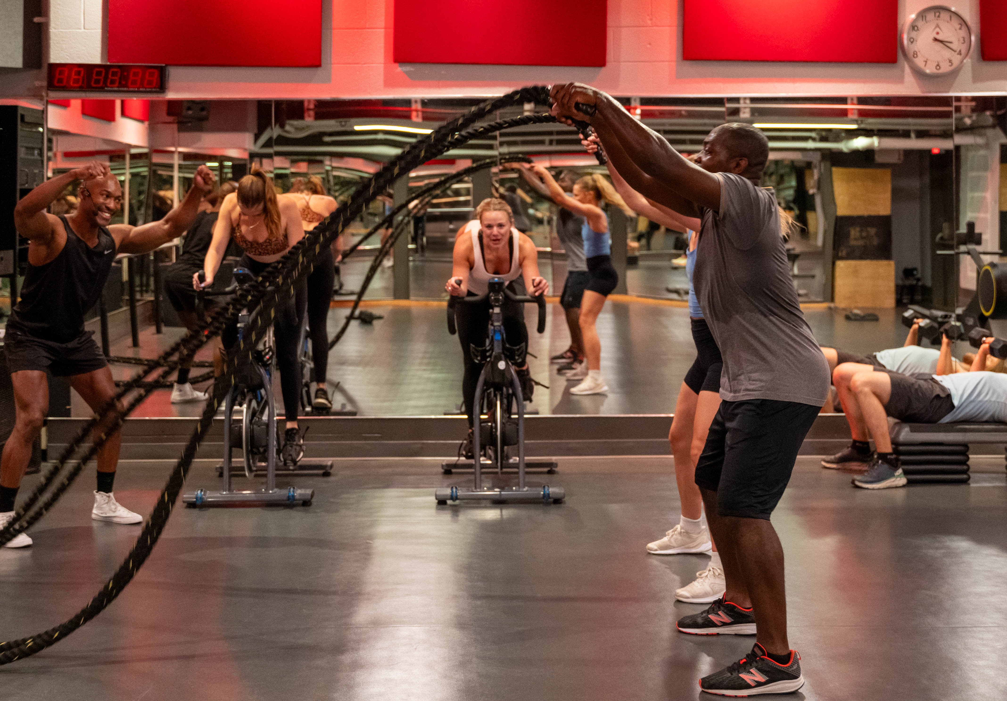 Circuit workout class in the Adelaide Club featuring battle ropes, stationary bikes, and weight training