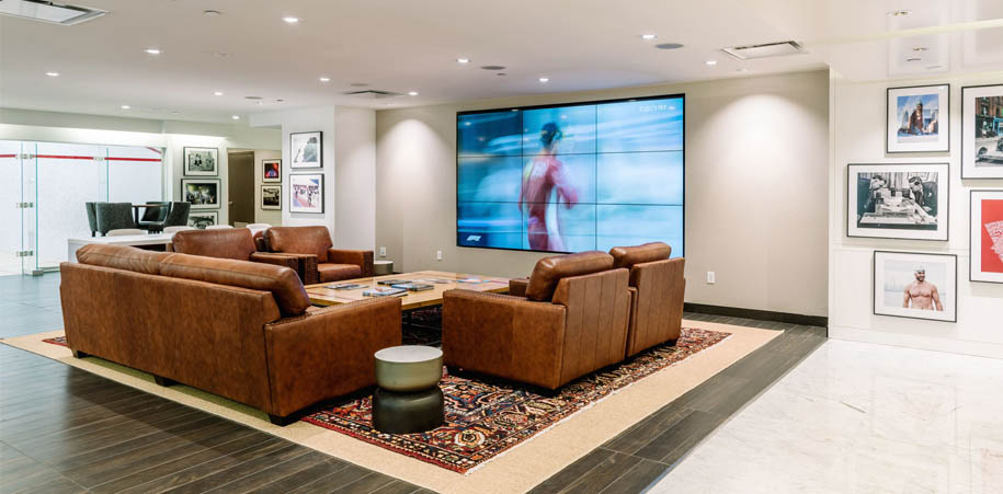 Comfortable couch and chairs in front of the big screen tv in the WorkHUB at the Adelaide Club
