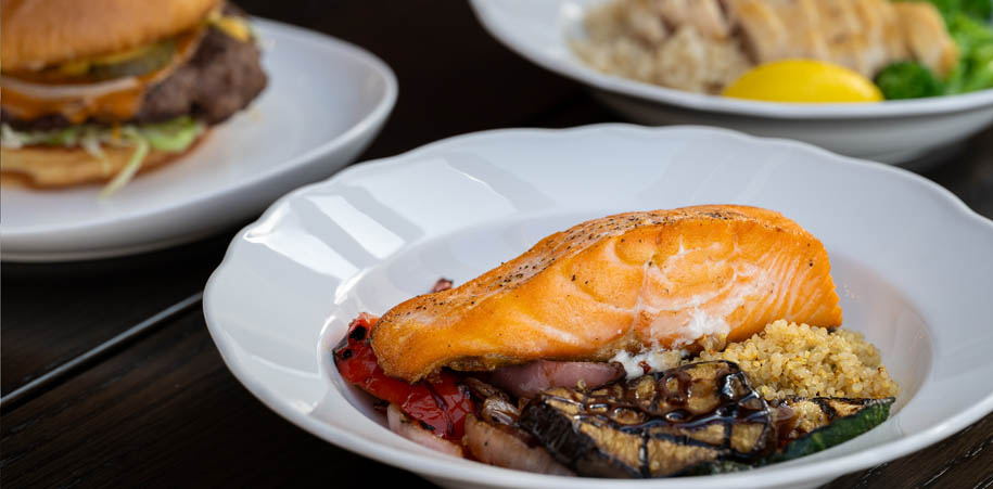 Macro Salmon Bowl served in the HUB, and a Boast Burger & Macro Chicken Bowl in the background