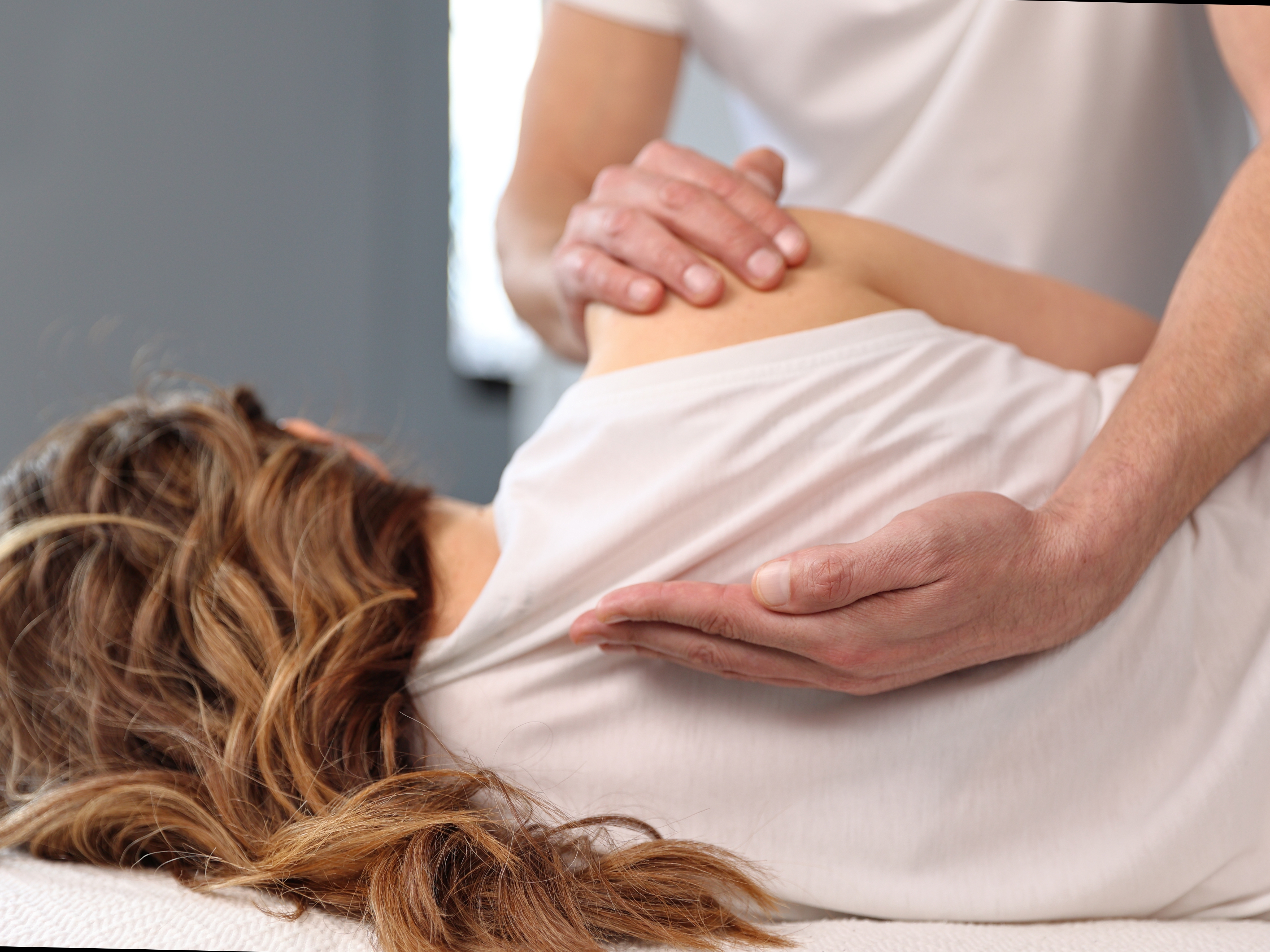 Osteopath working on woman's back